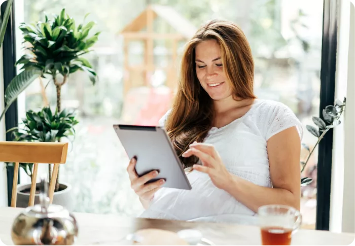 Mère de famille utilisant une tablette et souriant
